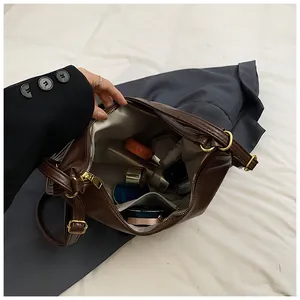 Top view showing the spacious interior of a dark brown tote bag with makeup items