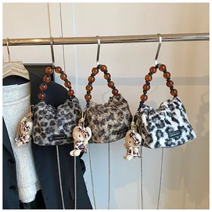 Detailed view of leopard print plush handbags with amber beaded handles and metal chain straps