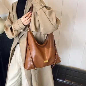 Vintage brown large capacity tote bag with gold hardware worn by model in trench coat