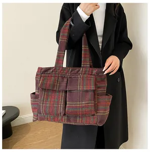 Detail view of large plaid tote bag with red and green contrast patterns and utility pockets