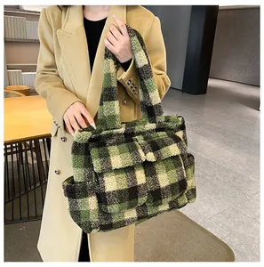 Detail of soft green and black checkered plush tote bag with multi-pocket design on model