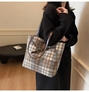 Makroaufnahme der karierten Tweed-Tasche mit blau-weiß-braunem Muster und seitlichem Reißverschluss
