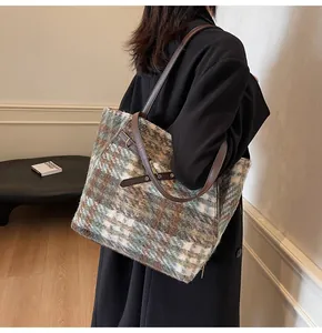 Detailansicht der großen Tweed-Schachbrett-Tasche mit Lederriemen an einem Modell
