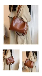 Macro detail of brown leather tote bag showing smooth texture and logo branding