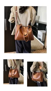 Detail of a large brown vintage tote bag showing wide woven strap and smooth leather texture