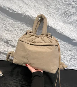 Detailed close-up of khaki padded nylon drawstring handbag with soft puffed handle
