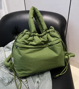 Macro detail of grass green quilted nylon down bag showing zip pocket and soft texture