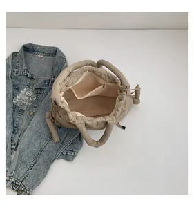 Macro view of interior storage with zipper pocket and drawstring closure on puffy tote bag