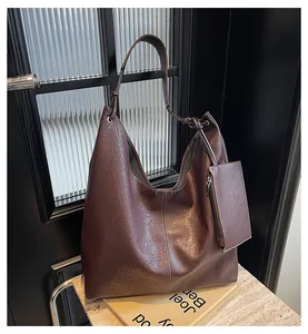Close-up of chocolate brown leather tote bag with white stitching and knotted strap detail