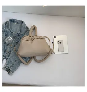 Flat lay of beige quilted puffer tote bag with drawstring and everyday essentials