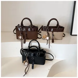 Detailed display of large capacity tote bags in dark brown, beige, and black with sports charms
