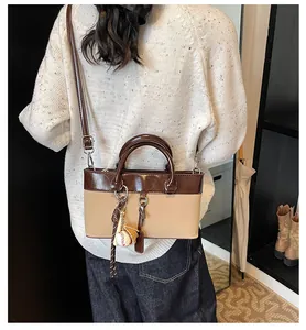 Detail of two-tone shoulder bag featuring brown leather top and beige matte bottom