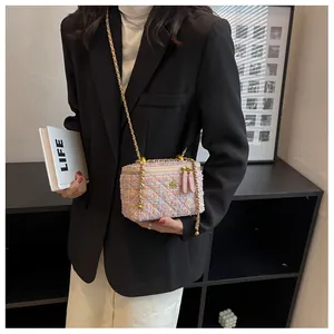 Détail du mini sac boîte en tweed rose avec chaîne dorée et fermoir floral