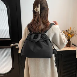 Black quilted puffer backpack for women with drawstring closure and stylish padded texture