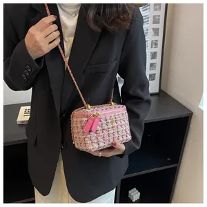 Détail de la texture en tweed rose et de la bandoulière en chaîne dorée du mini sac