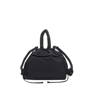 Quilted black puffer tote bag with drawstring detail and minimalist aesthetic