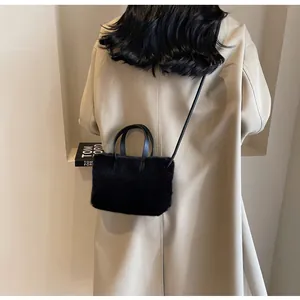 Sac bandoulière tendance en fausse fourrure noire avec sangle en cuir vue de dos
