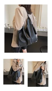 Detail of large black matte leather tote bag with a matching small zipper pouch charm