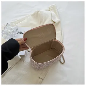 Dettaglio della mini borsa a secchiello in maglia tweed rosa con catena dorata