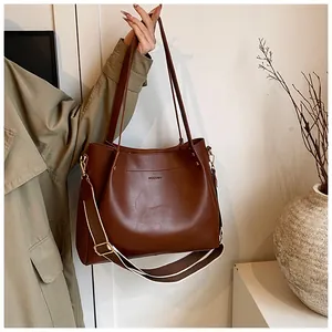 Detail of dark brown leather tote bag with a wide color-block detachable shoulder strap
