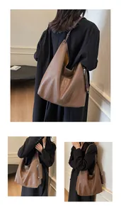 Detail view of large dark brown soft leather tote bag with a small zipper pouch accessory