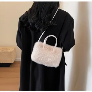 Vue détaillée du sac en peluche beige avec fausse fourrure douce et lanières en similicuir