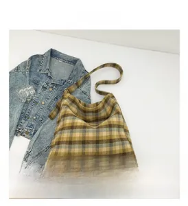 Detail view of large checkered tote bag paired with denim jacket for casual style