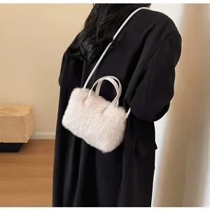 Détail du sac à main en peluche crème montrant la texture douce et les anses en cuir