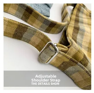 Detail of adjustable shoulder strap on brown checkered tote bag with silver metal buckle