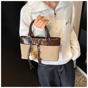 Detail of vintage tote bag with contrast patent leather and baseball theme charms