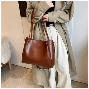 Detailed close-up of dark brown faux leather tote bag with elegant brand logo engraving