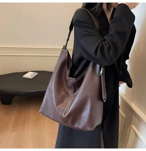 Detail view of large dark brown hobo bag with contrast stitching and soft litchi texture