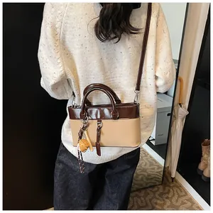 Detail of vintage two-tone tote bag in dark brown and beige with decorative charms
