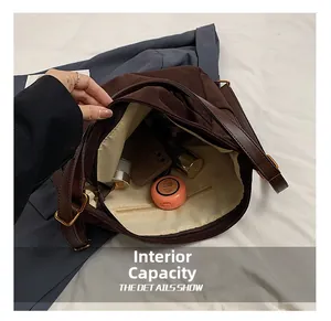Vista macro che mostra la capiente capacità interna e la tasca con zip della borsa scamosciata