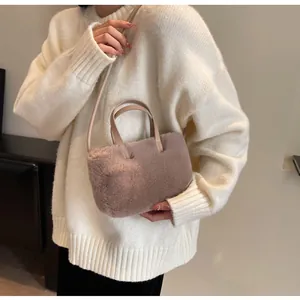 Vue détaillée du sac à main en peluche rose poudré avec de fines anses en cuir