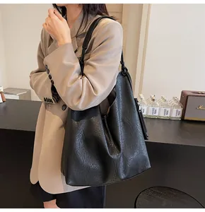 Macro shot of textured black soft leather hobo bag with wide shoulder strap details