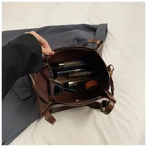 Macro shot of large capacity brown leather tote bag interior with zipper pocket and cosmetics