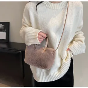 Mannequin portant un sac à main en peluche rose avec une fine bandoulière en cuir