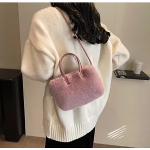 Détail du sac à main en peluche rose montrant la texture douce et la bandoulière en cuir