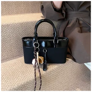 Detail of black patchwork tote bag with baseball charms on a soft staircase setting