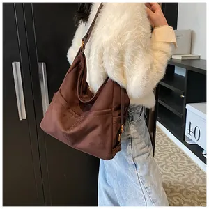 Dettaglio della grande borsa hobo marrone scuro con fibbia in metallo e tasca laterale
