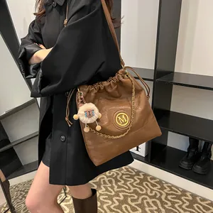 Grand sac à bandoulière en cuir marron avec logo M doré et pendentif mouton doux