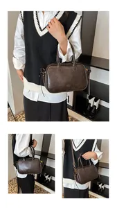 Detail of vintage dark brown Boston bag featuring golden lettering and adjustable strap