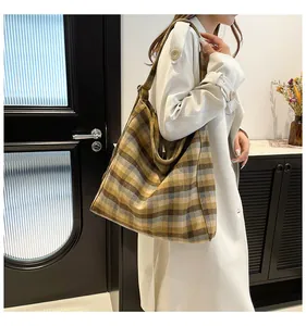 Detail of yellow plaid tote bag on shoulder showing its large capacity and thick fabric texture