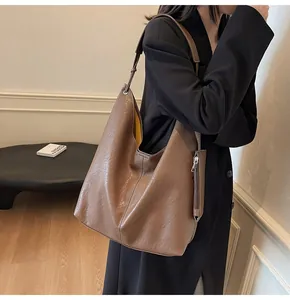 Detail of a brown leather Hobo bag with contrast stitching and bright yellow lining