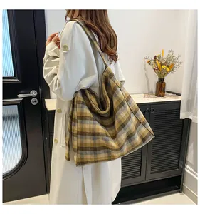 Detailed side view of the brown plaid tote bag showing its large capacity on a model