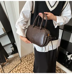 Detail view of the dark brown Boston bag with a unique drawstring bow and matte finish