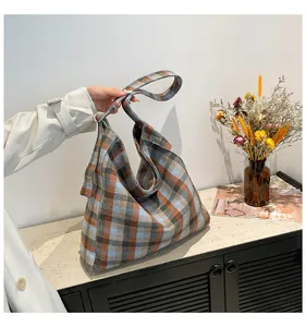 Close-up of large plaid tote bag showing soft crescent shape and textured wool fabric