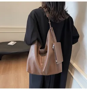 Detail of soft brown leather hobo bag showing litchi texture and detachable small coin pouch