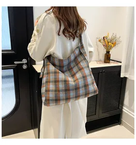 Close-up of a large vintage plaid tote bag in warm brown and blue wool fabric
